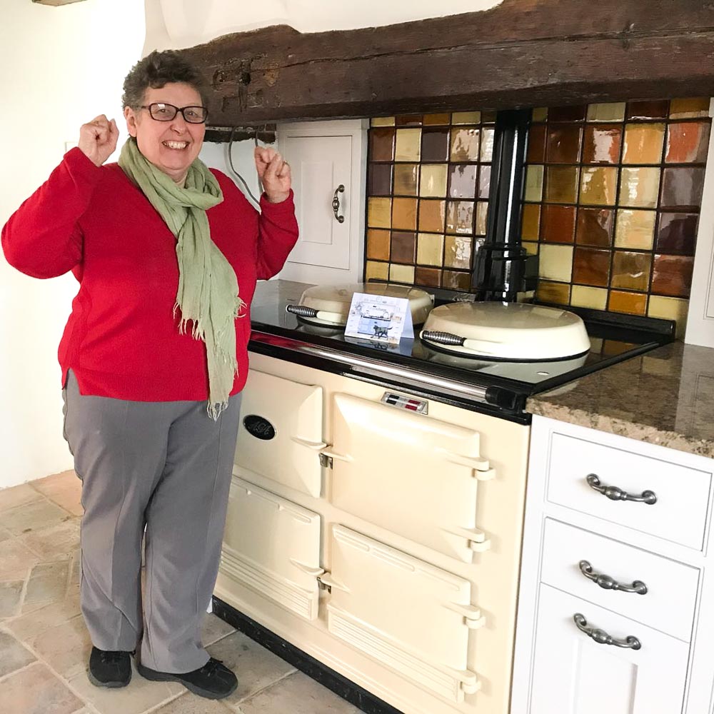 Gill looks excited next to her aga cooker