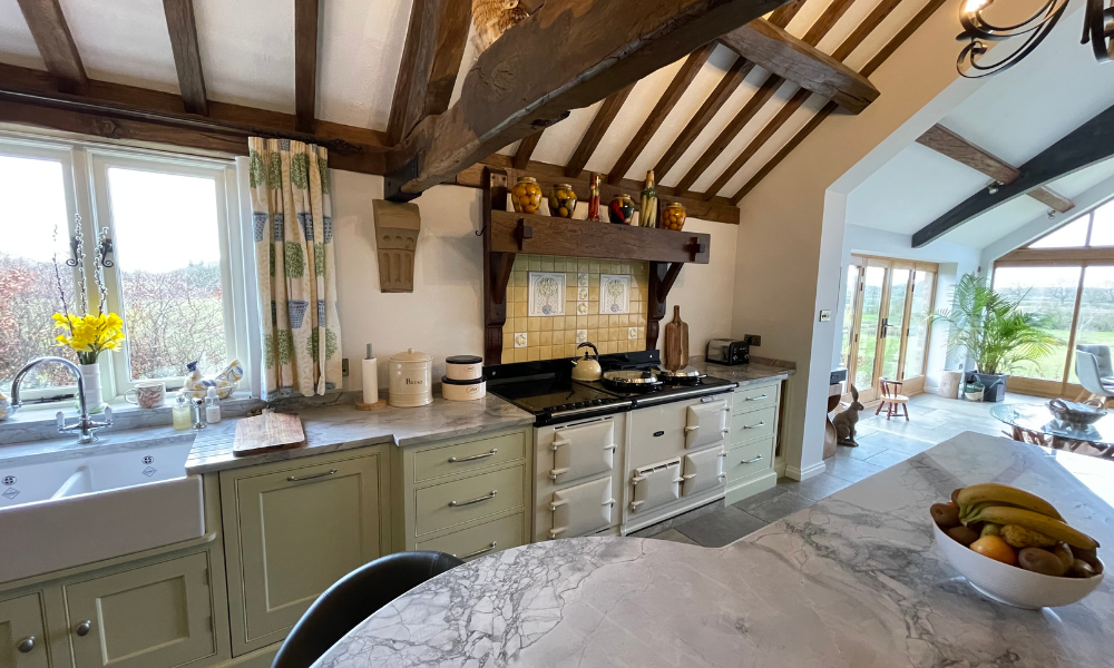 picture of a linen aga cooker in a farmhouse style ktichen with wooden beams