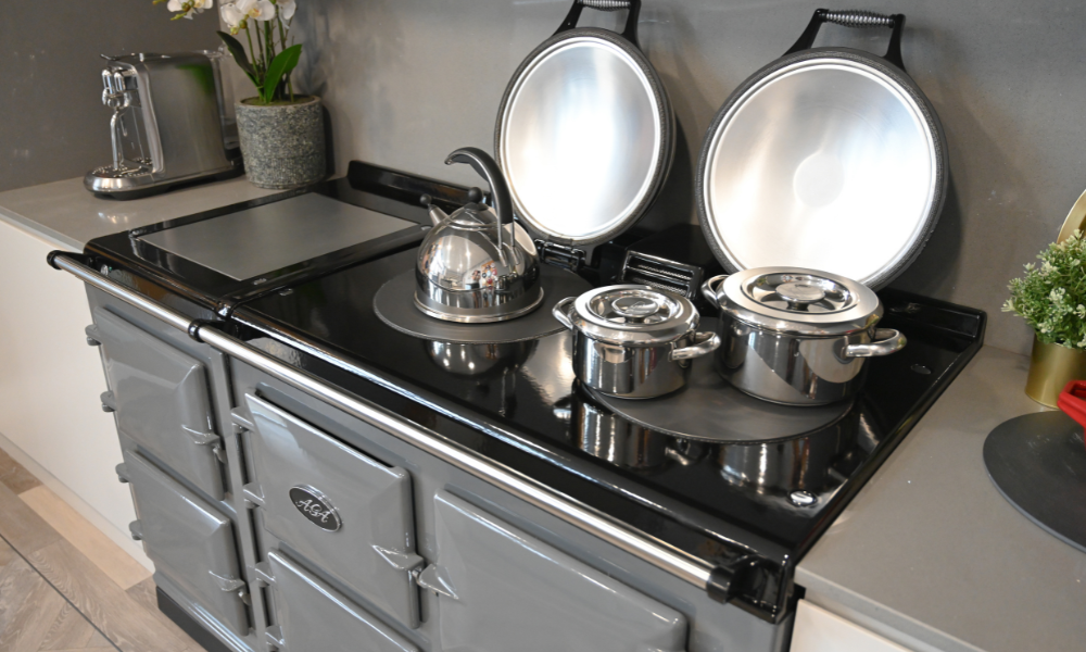 Image of an Aga cooker with lids up and pans on the hotplates