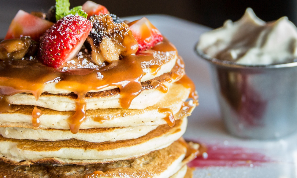 A stack of pancakes with fruit on for cooking pancakes on an aga